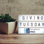 Giving Tuesday word in light box on wooden background